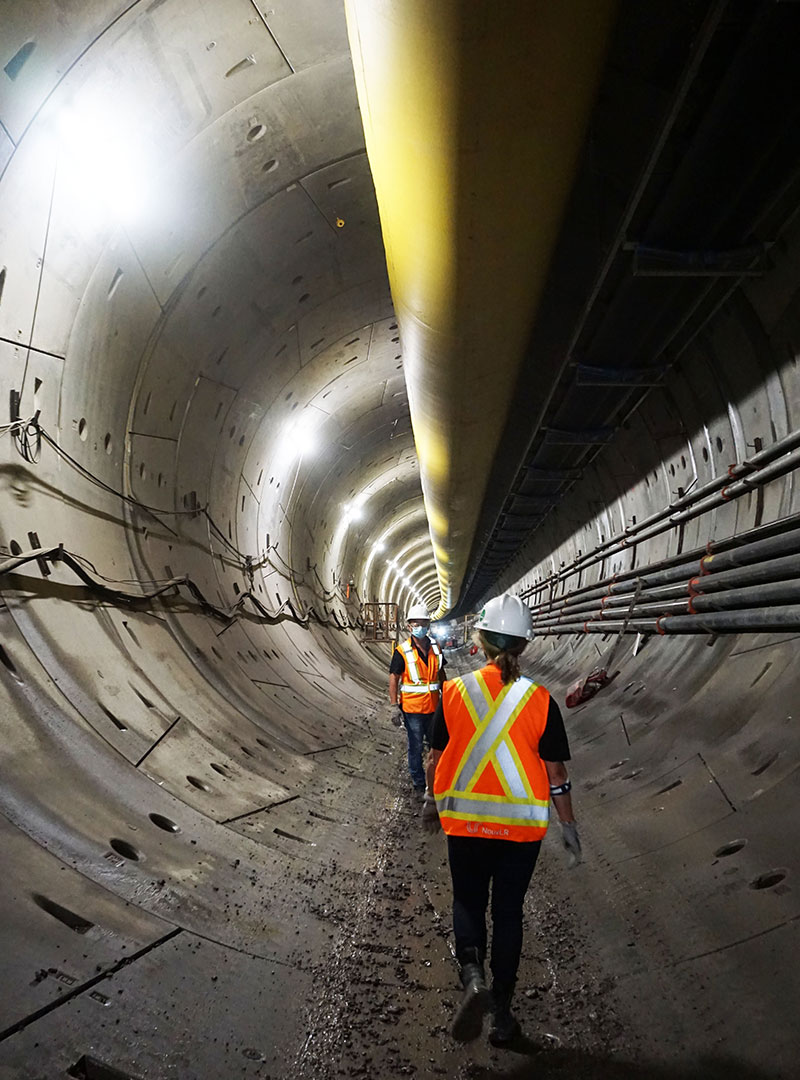 Photo de travailleurs qui circulent dans le tunnel construit avec le tunnelier.