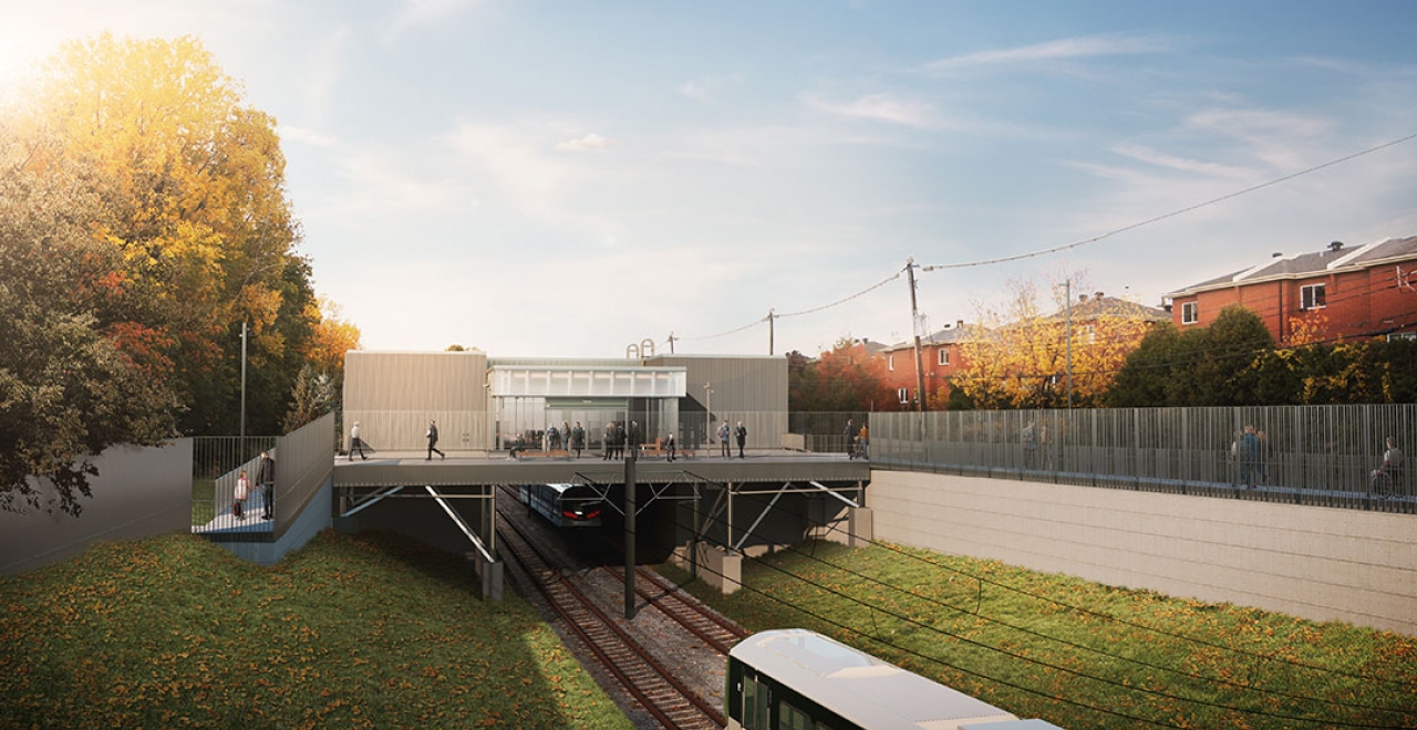 Vue à hauteur d’usager, où l’on voit des usagers accéder à la place d’entrée de la station, sécurisée par des clôtures anti-intrusion. La station fait partie du tronçon « urbain mixte », qui est caractérisé par la couleur rouge brique. On retrouve cette couleur dans la céramique à l’intérieur, dans le mobilier urbain et dans les aménagements paysagers aux abords de la station. / Image à titre indicatif seulement. 